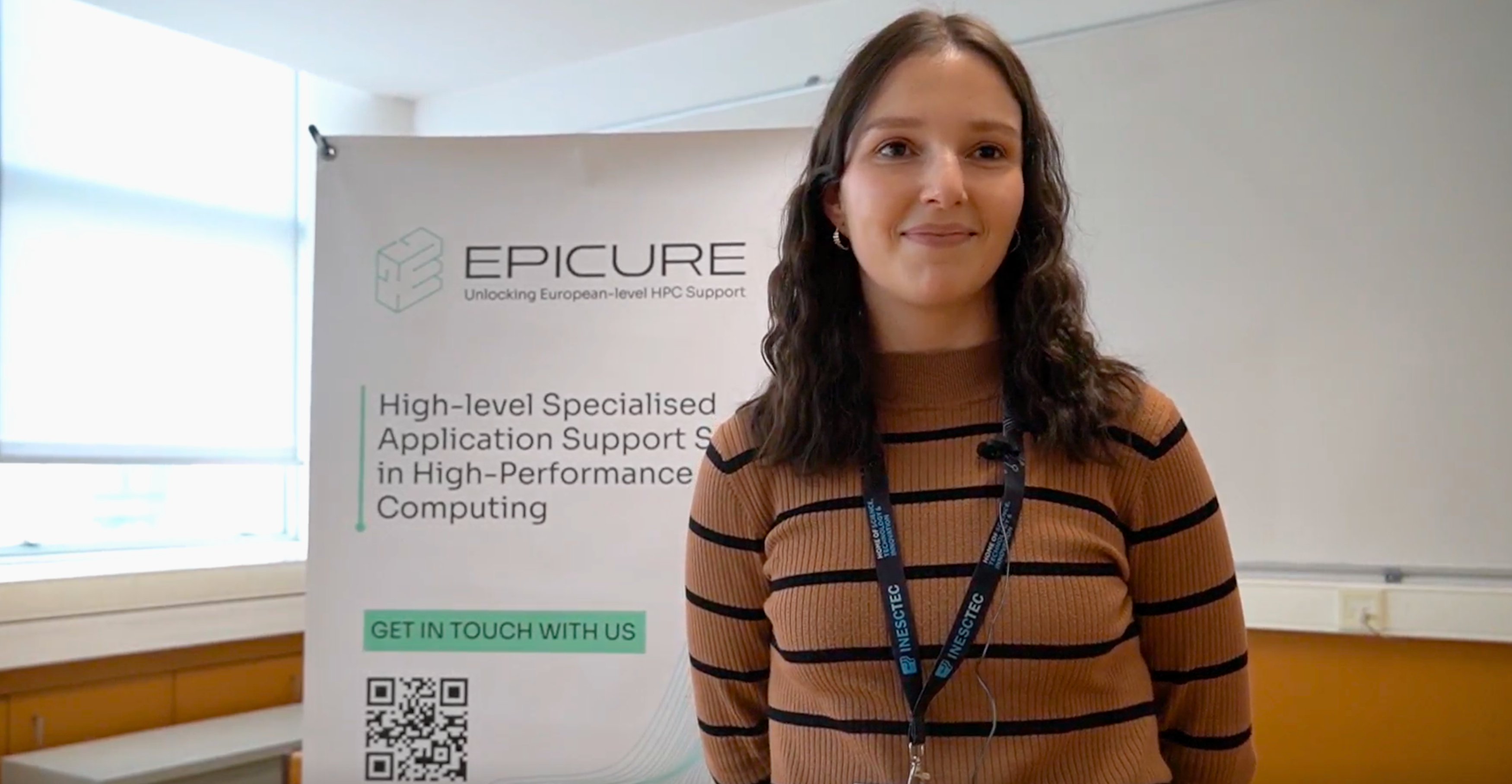 Woman with a brown sweater in front of a roll-up with EPICURE logo.