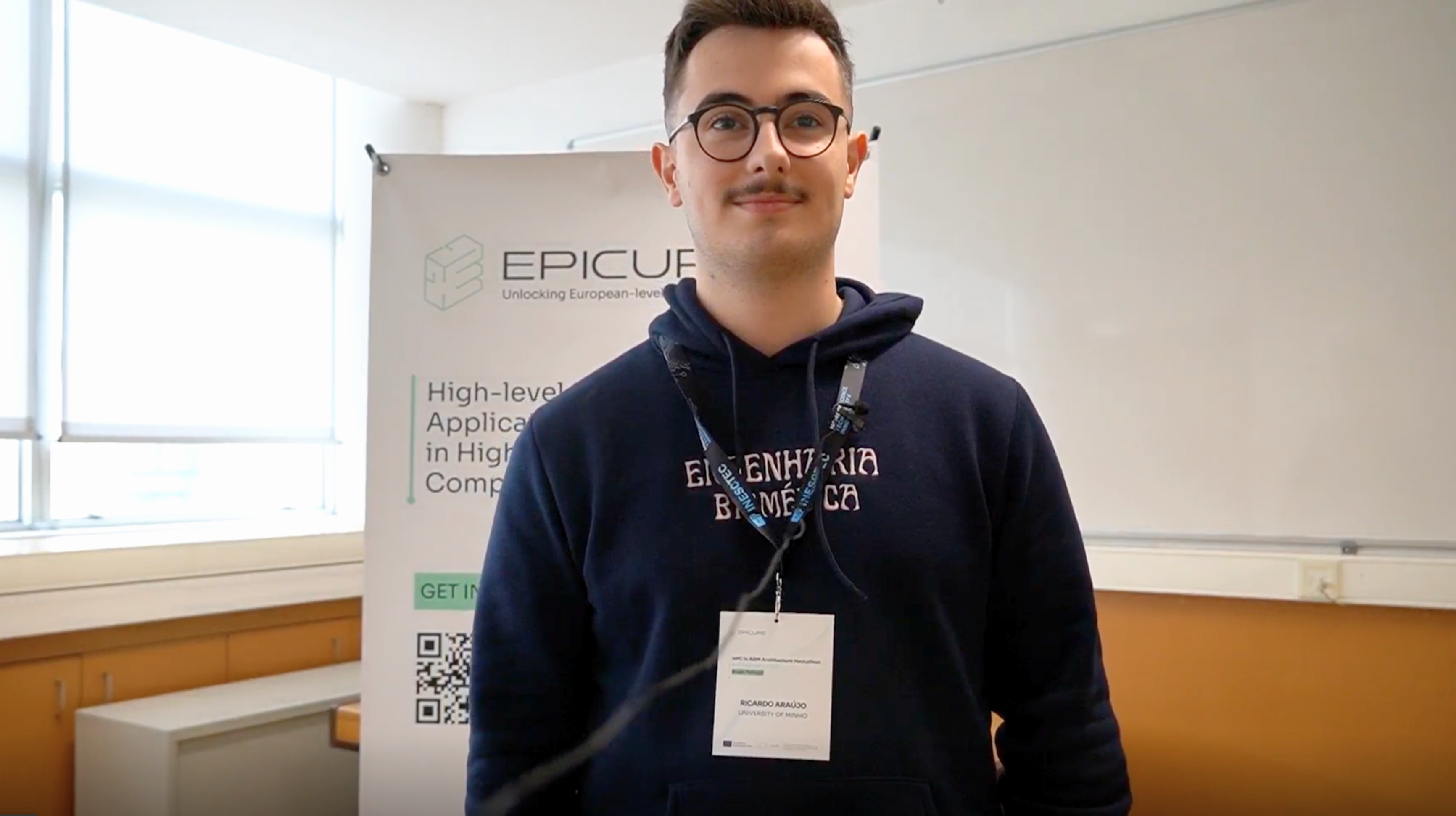 Man with a dark sweater in front of a roll up with EPICURE logo.