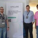 Three participants standing beside an EPICURE banner promoting high-level HPC application support, at a conference booth area.