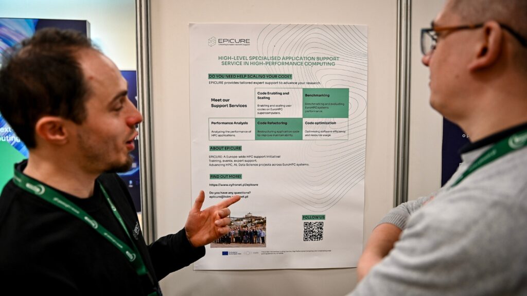 Two attendees discussing an EPICURE poster on high-performance computing support services, with one person pointing at the displayed information.