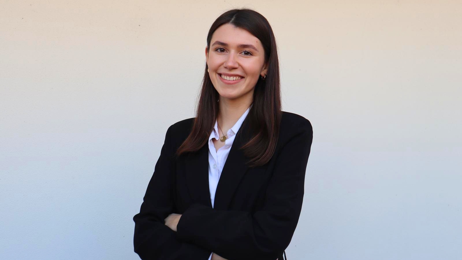 Woman wearing a white shirt and a black blazer.