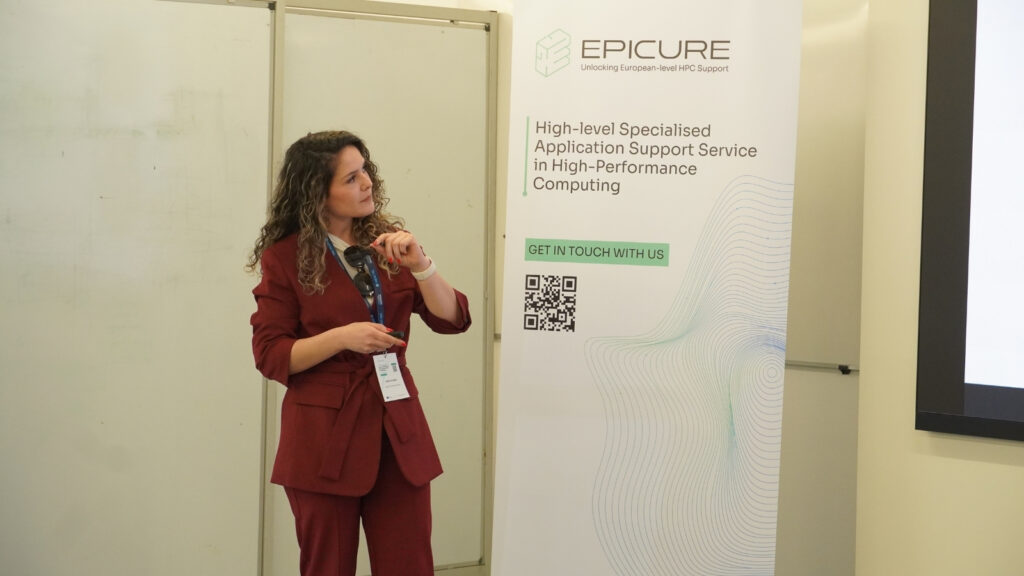 Speaker presenting in front of an EPICURE banner, addressing an audience during a high-performance computing workshop session.