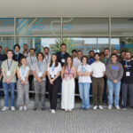 Group of participants posing for a photo outside an INESC TEC building, wearing conference badges during an HPC-related event.