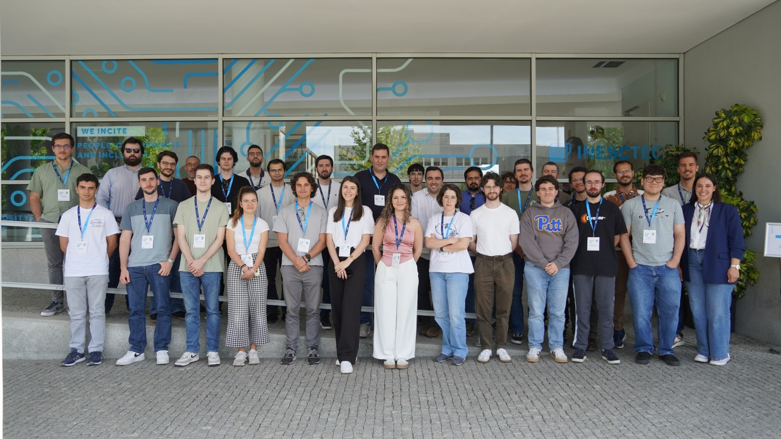 Group of participants posing for a photo outside an INESC TEC building, wearing conference badges during an HPC-related event.