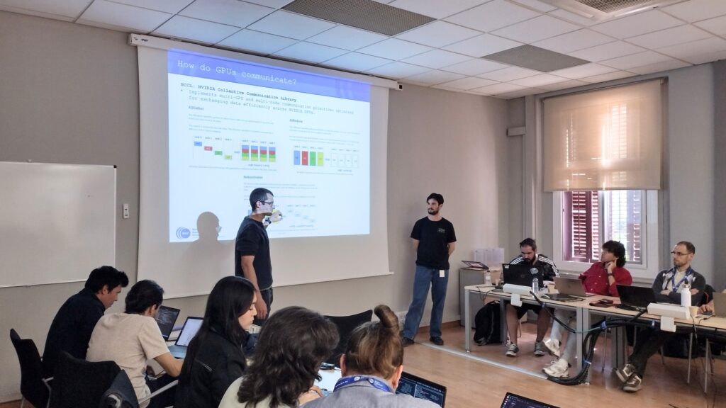 Participants working on laptops attend a technical HPC workshop session, with two presenters explaining NCCL-based multi-GPU communication techniques.