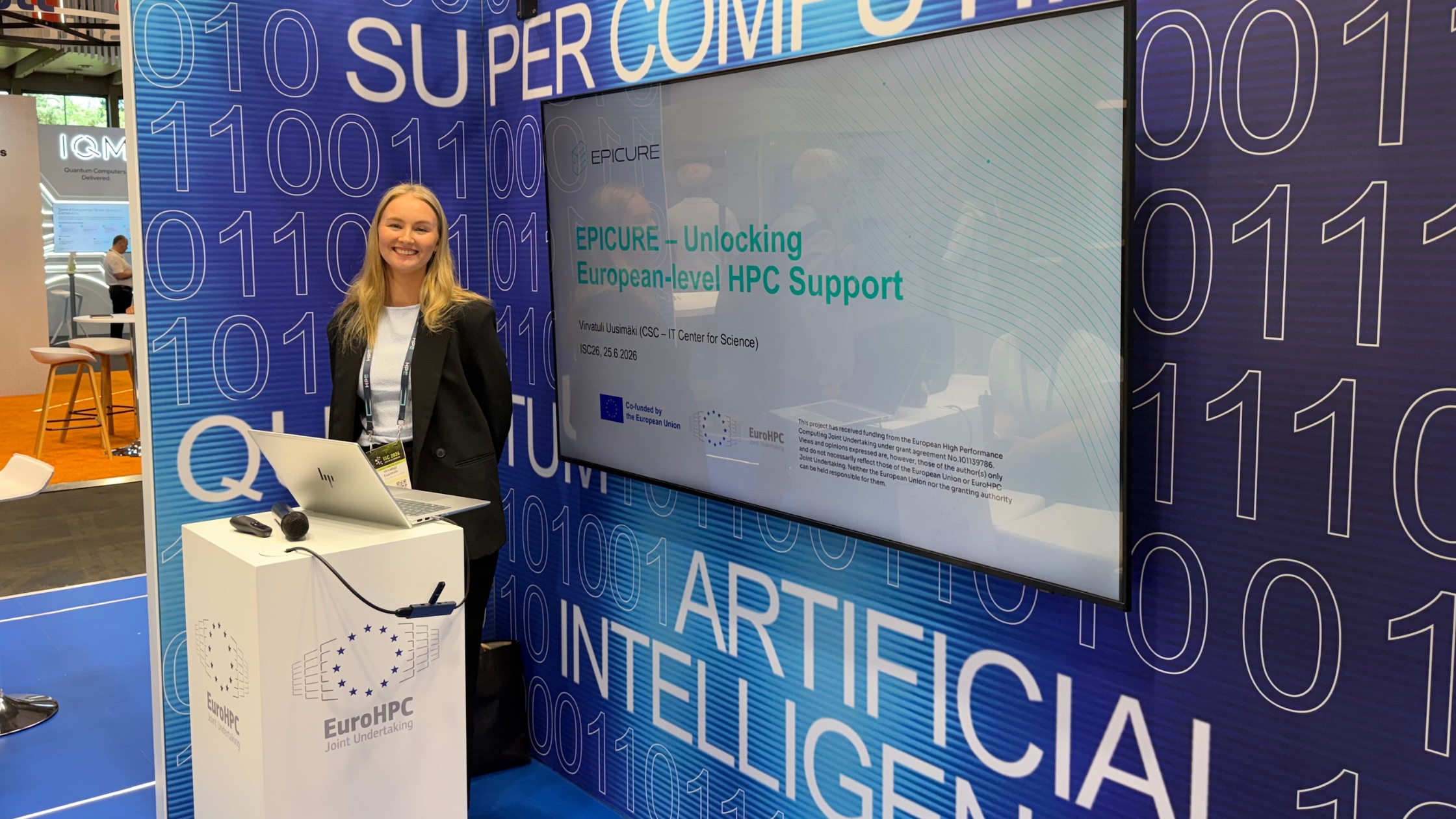 Woman presenting the EPICURE project at the EuroHPC Joint Undertaking booth during ISC High Performance 2026 in Hamburg.