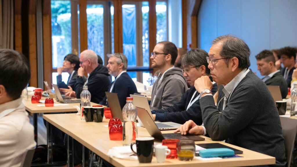 Attendees follow a presentation at the HANAMI High-Level Symposium, engaging in discussions.